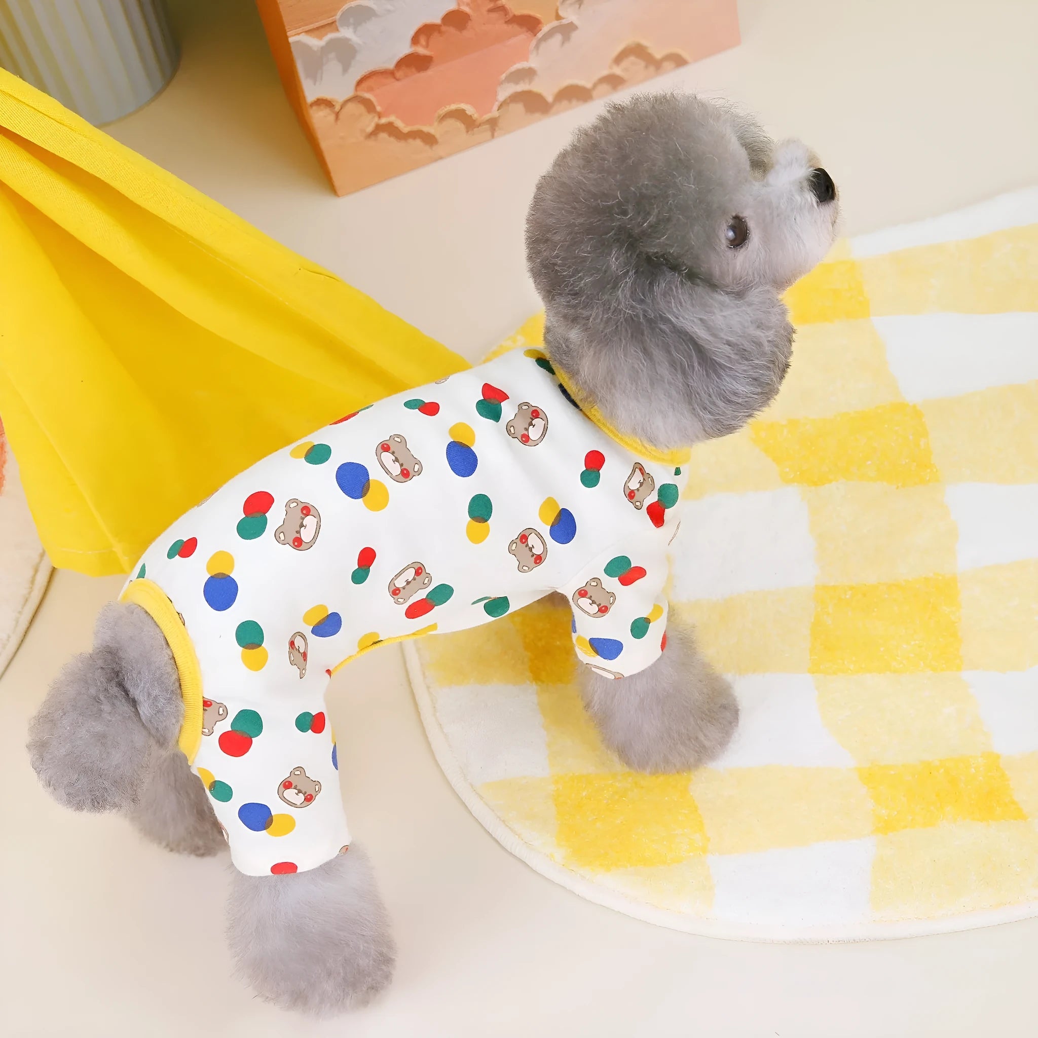 Beige dog t-shirt with a colourful cartoon ball bear design, showing a casual fit on a pet.