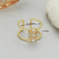 Gold-coloured adjustable open ring with an asymmetric U-shaped design on a white background.
