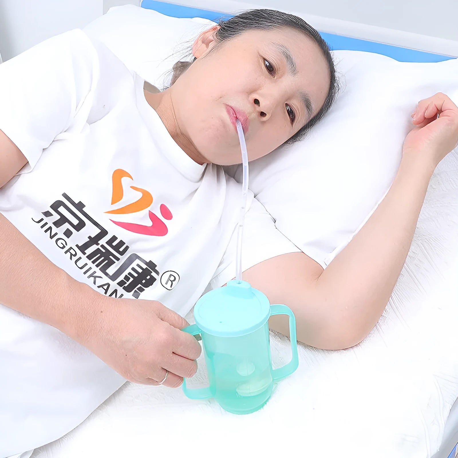 A white PP plastic choke proof drinking cup with a lid and handle for elderly and pregnant adult bed care.