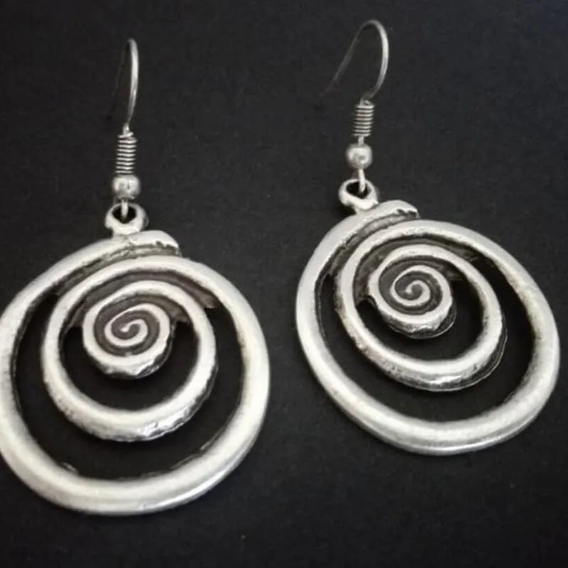 A pair of retro-style geometric spiral earrings with a distressed silver finish.