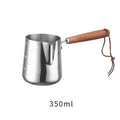 Stainless steel latte art milk frothing jug with measurement scale and wooden handle