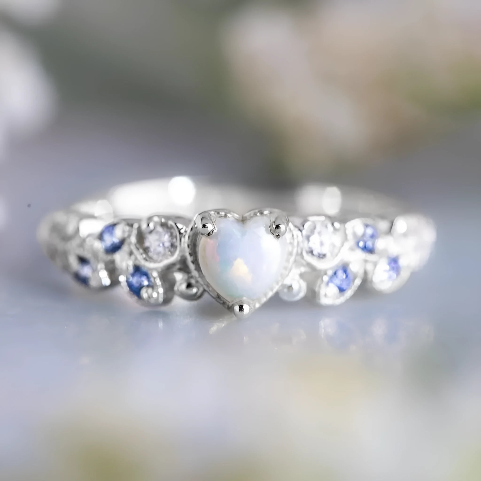 White electroplated alloy women's ring in a peach heart shape with flower and opal ocean design details.