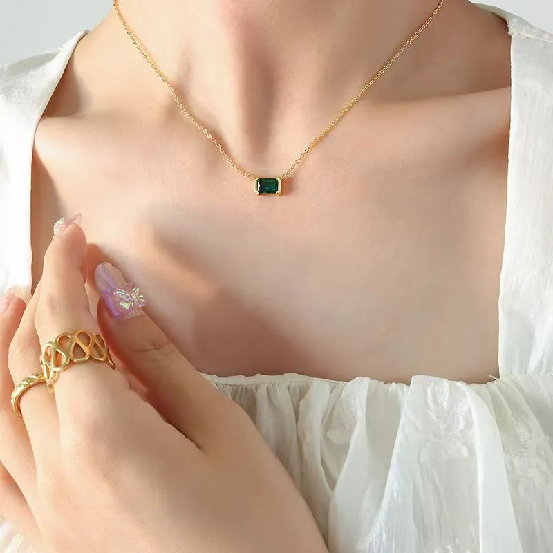 Gold-coloured geometric quadrilateral pendant necklace on a model, showing Lvzuan inlay detail on copper.