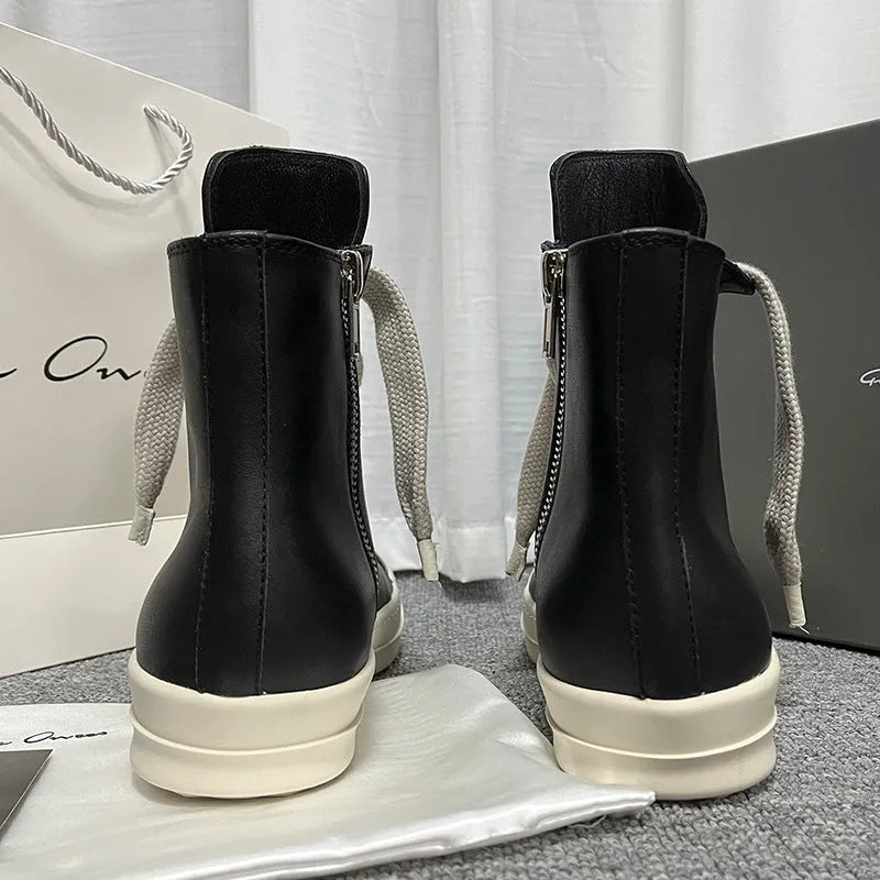 Black high-top leather sneakers with side zipper and round toe on a rubber sole.