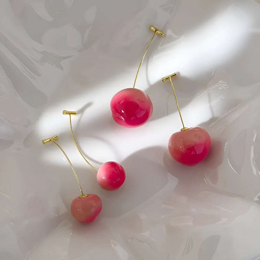 A pair of acrylic peach fruit earrings on a copper post, showing small and large size options.