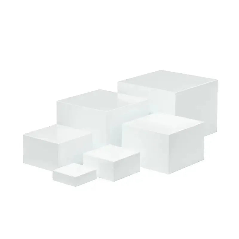 Six white modular plastic cube units arranged as a tiered dessert display stand holding cupcakes.