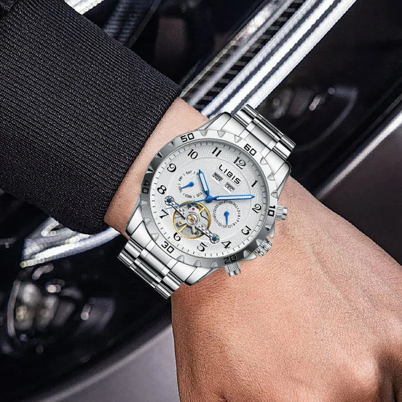 Silver men's automatic perpetual calendar mechanical watch with stainless steel strap on a wrist.