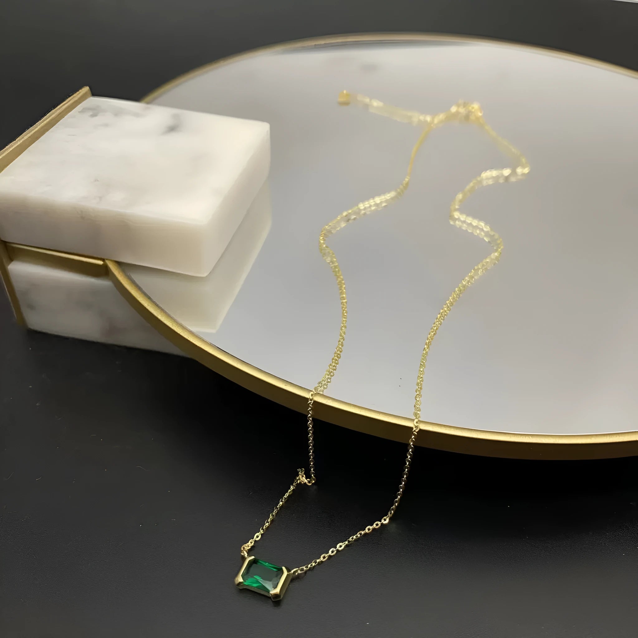 Gold-coloured geometric quadrilateral pendant necklace on a model, showing Lvzuan inlay detail on copper.