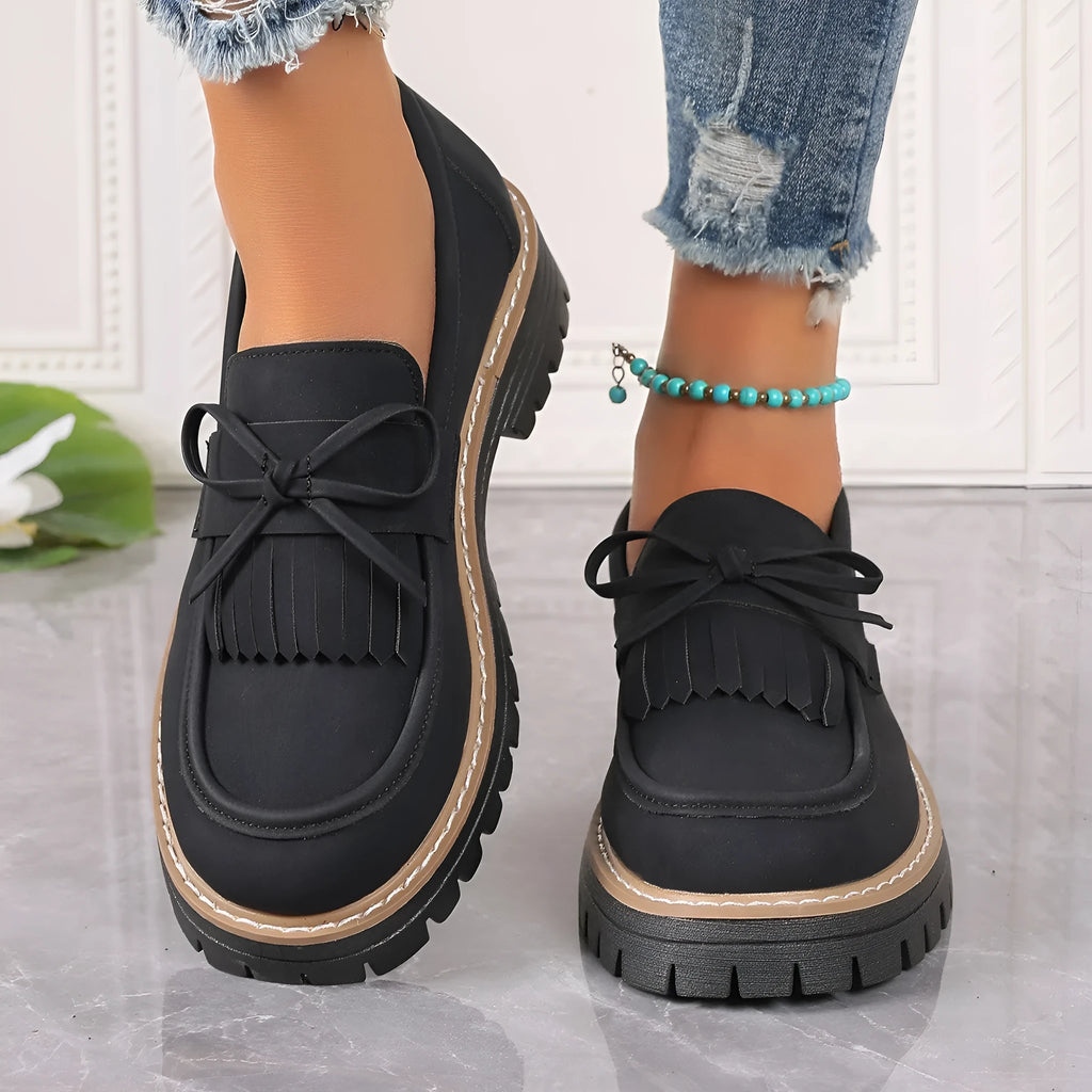 Black plus size women's loafers with tassel detail, bowknot, and a chunky low heel.