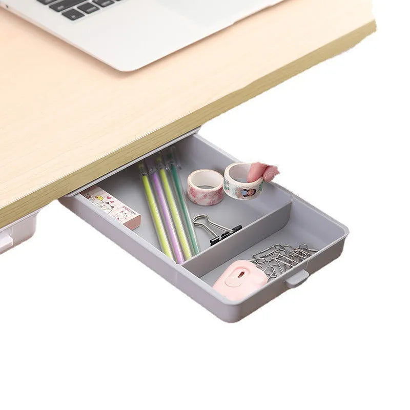 Small white plastic storage drawer with a cover and internal grid, shown placed under a wooden table.