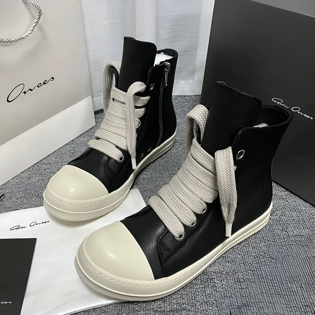 Black high-top leather sneakers with side zipper and round toe on a rubber sole.