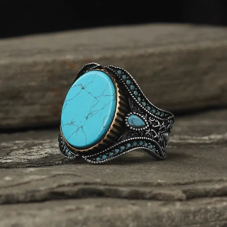 Men's antique silver ring with turquoise accent on finger showing simple round design