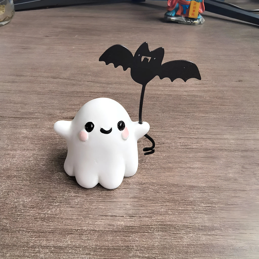 Miniature resin statue of a walking ghost dog holding a bat, a Halloween decoration.