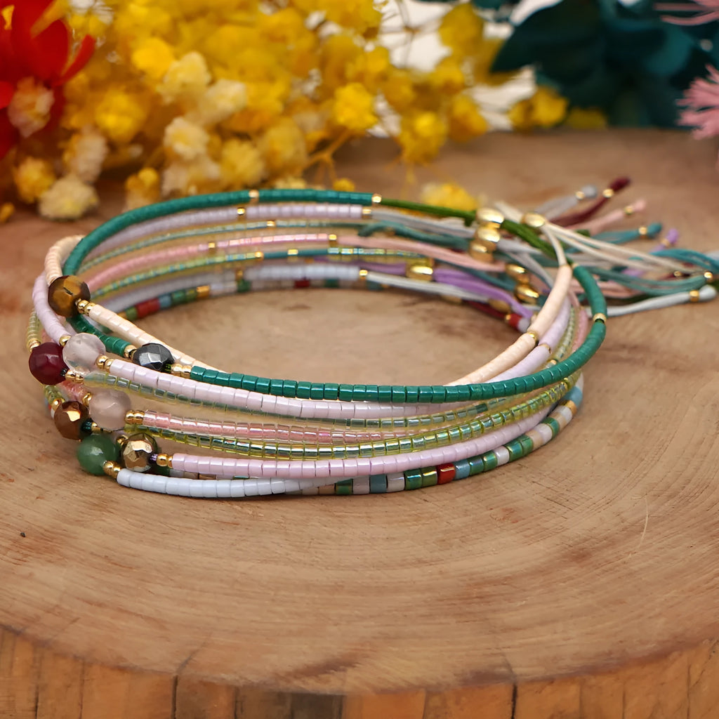 Close-up of a colourful handmade Bohemian bracelet with a lucky stone bead and geometric glass beads on a wrist.