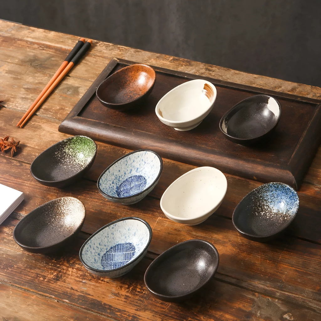 Oval Japanese ceramic dipping sauce bowl with Edo Pattern design on a dark surface.