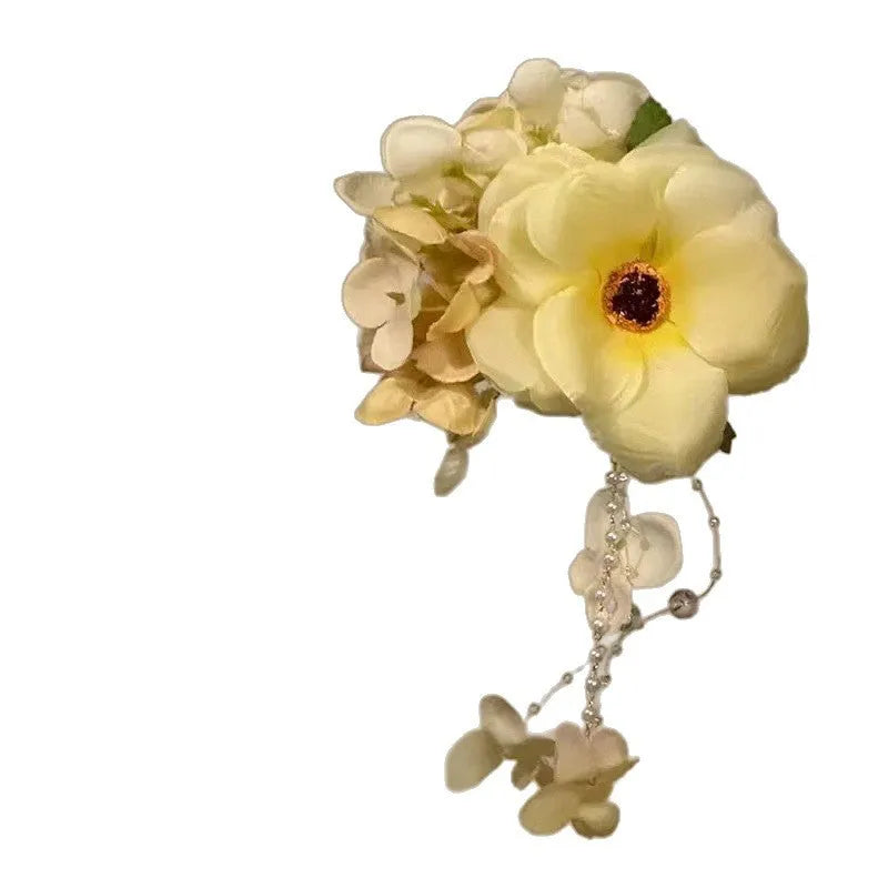 Yellow flower tassel side hair clip on a white background.