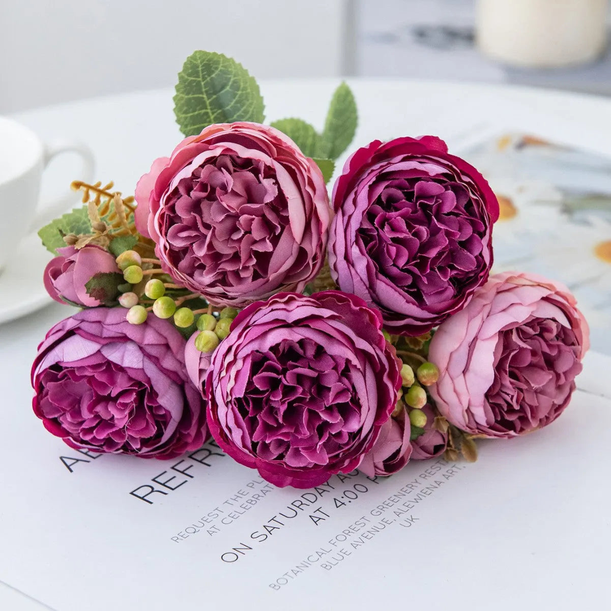 Artificial silk peony bouquet in champagne colour on a table.