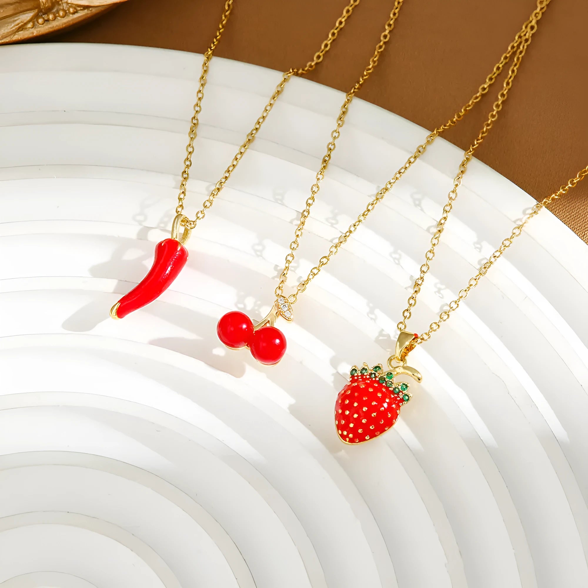 Golden titanium steel necklace with cherry, strawberry, and pepper pendant on O-ring chain.
