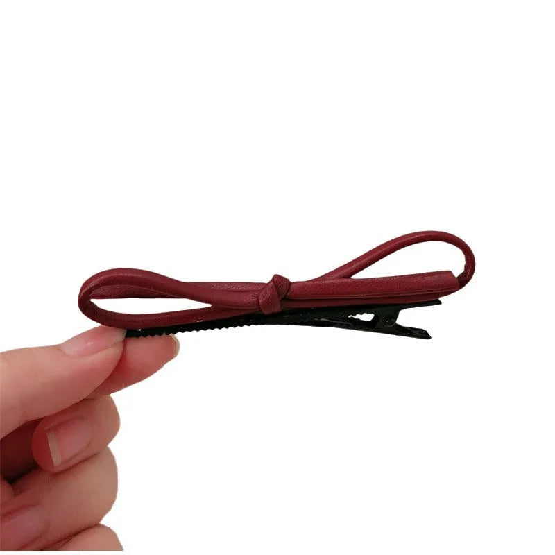 Wine red genuine leather bow hair clip barrette on a white background.