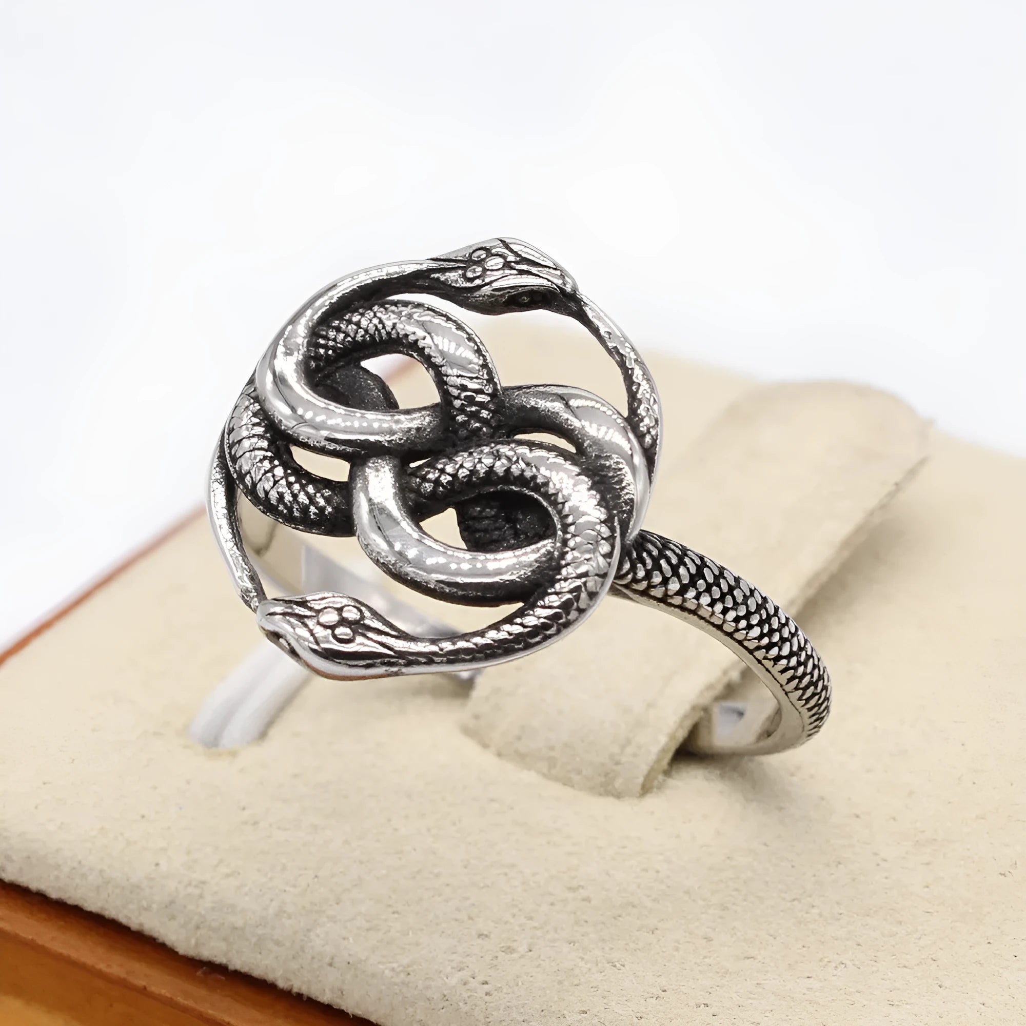 A titanium steel men's snake ring in steel colour showing a detailed twisted retro design on a finger.