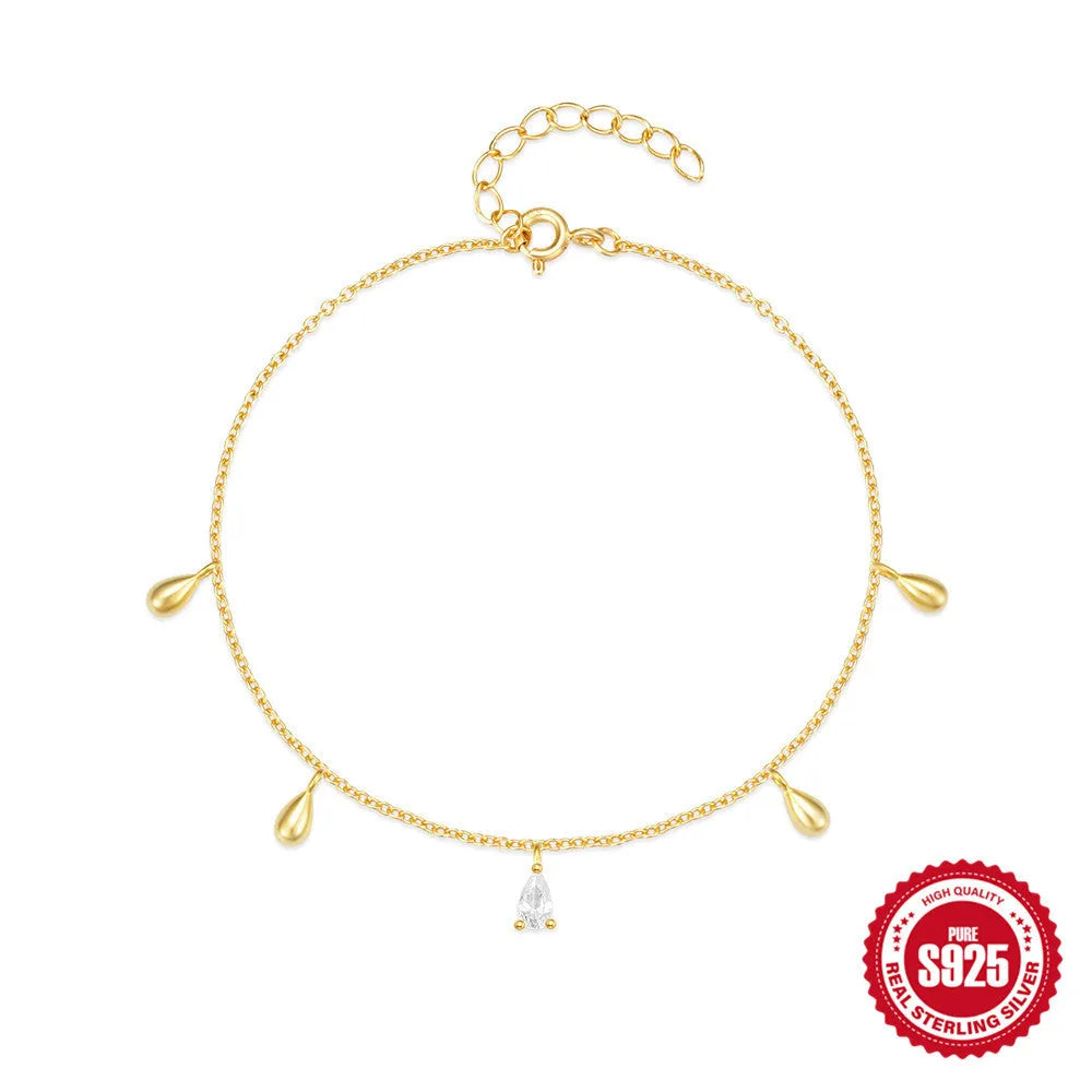 Gold plated sterling silver bracelet with a water droplet shaped diamond pendant on a woman's wrist
