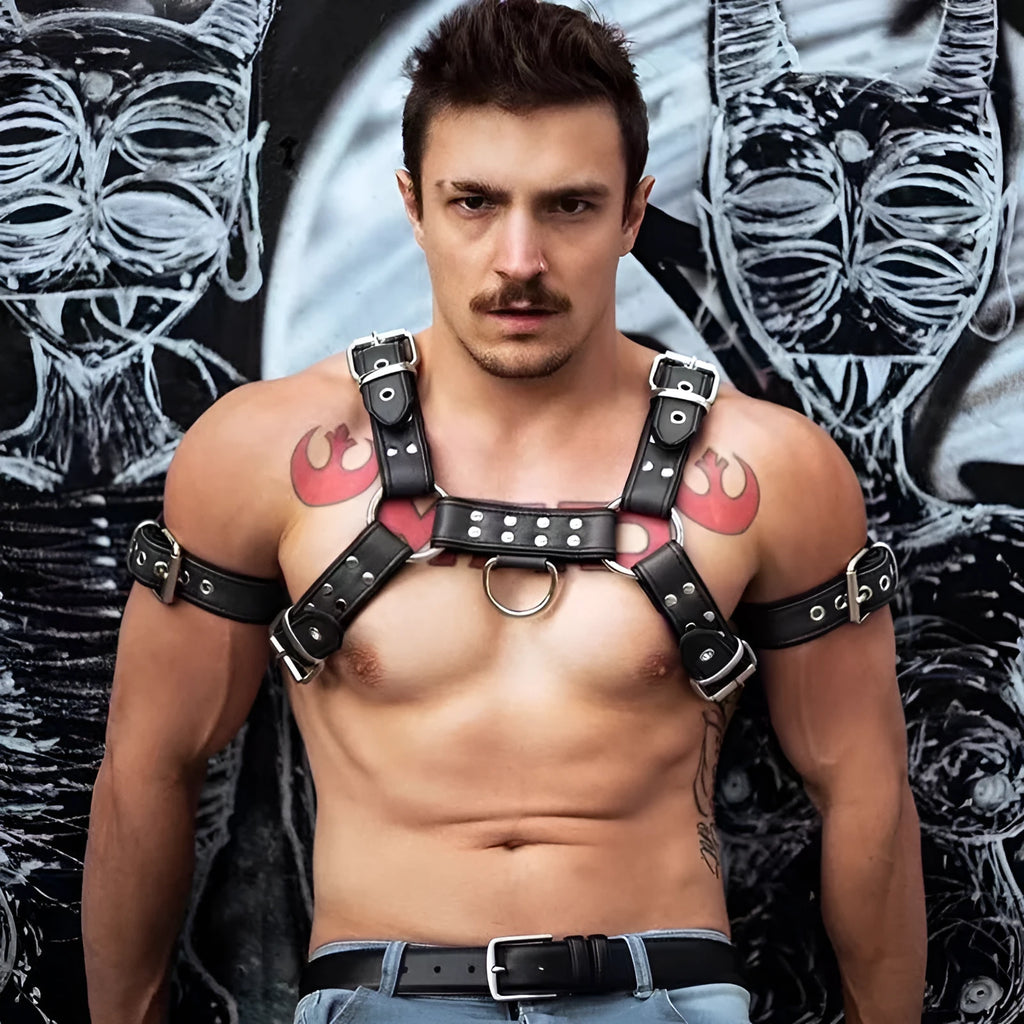 Black leather chest bondage strap with metal buckle and rivet detail on a mannequin