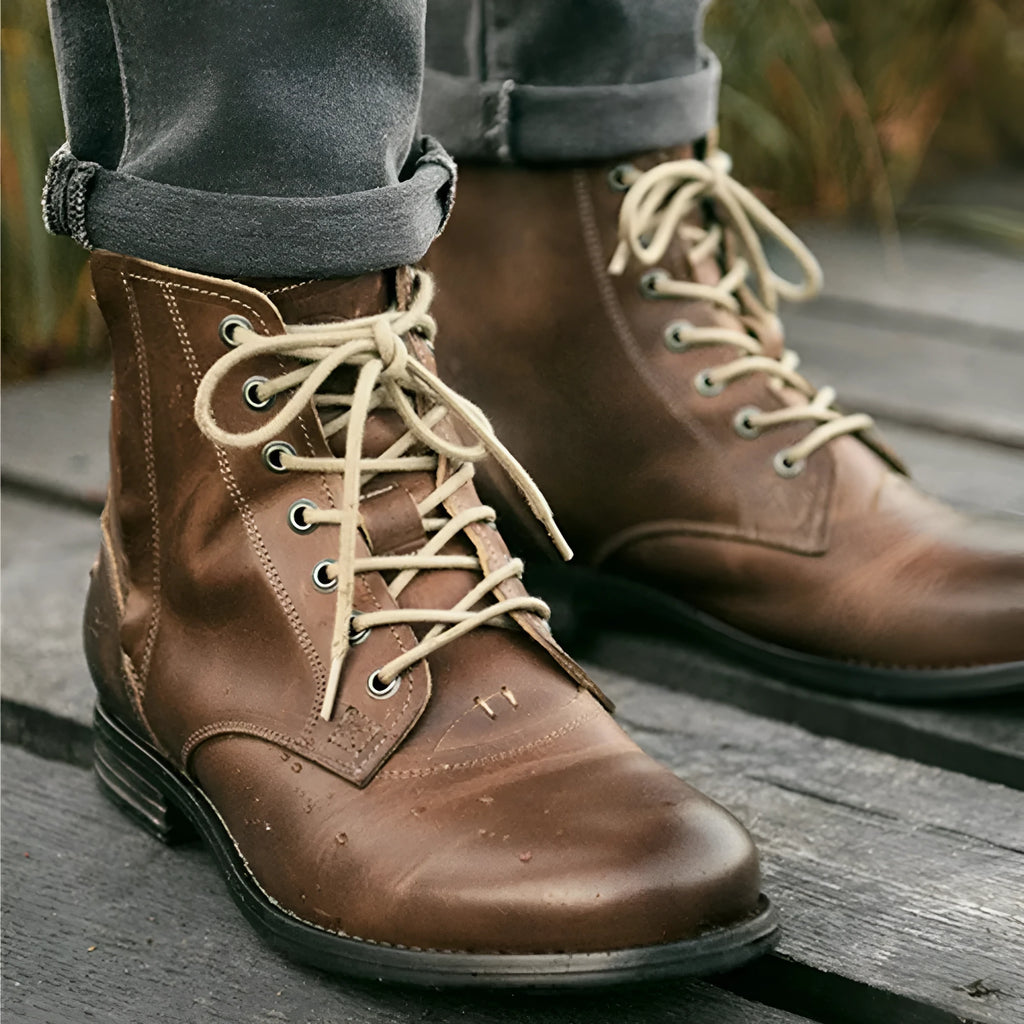 Men's black and brown two-tone leather ankle boots with a side zipper and low heel.