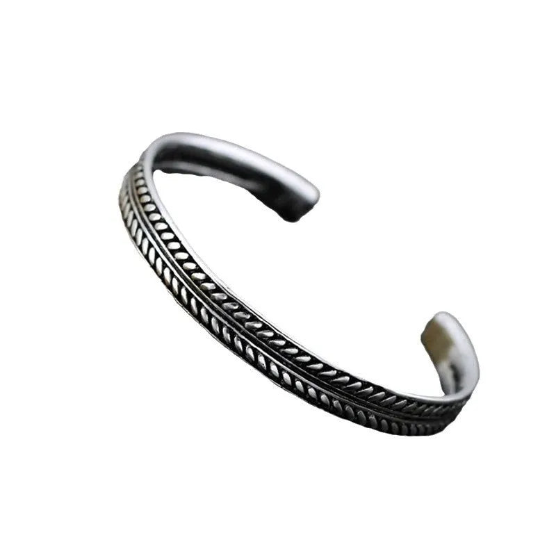 Close-up of a silver-toned women's bracelet with a detailed Chinese-style fish charm and an adjustable opening clasp.