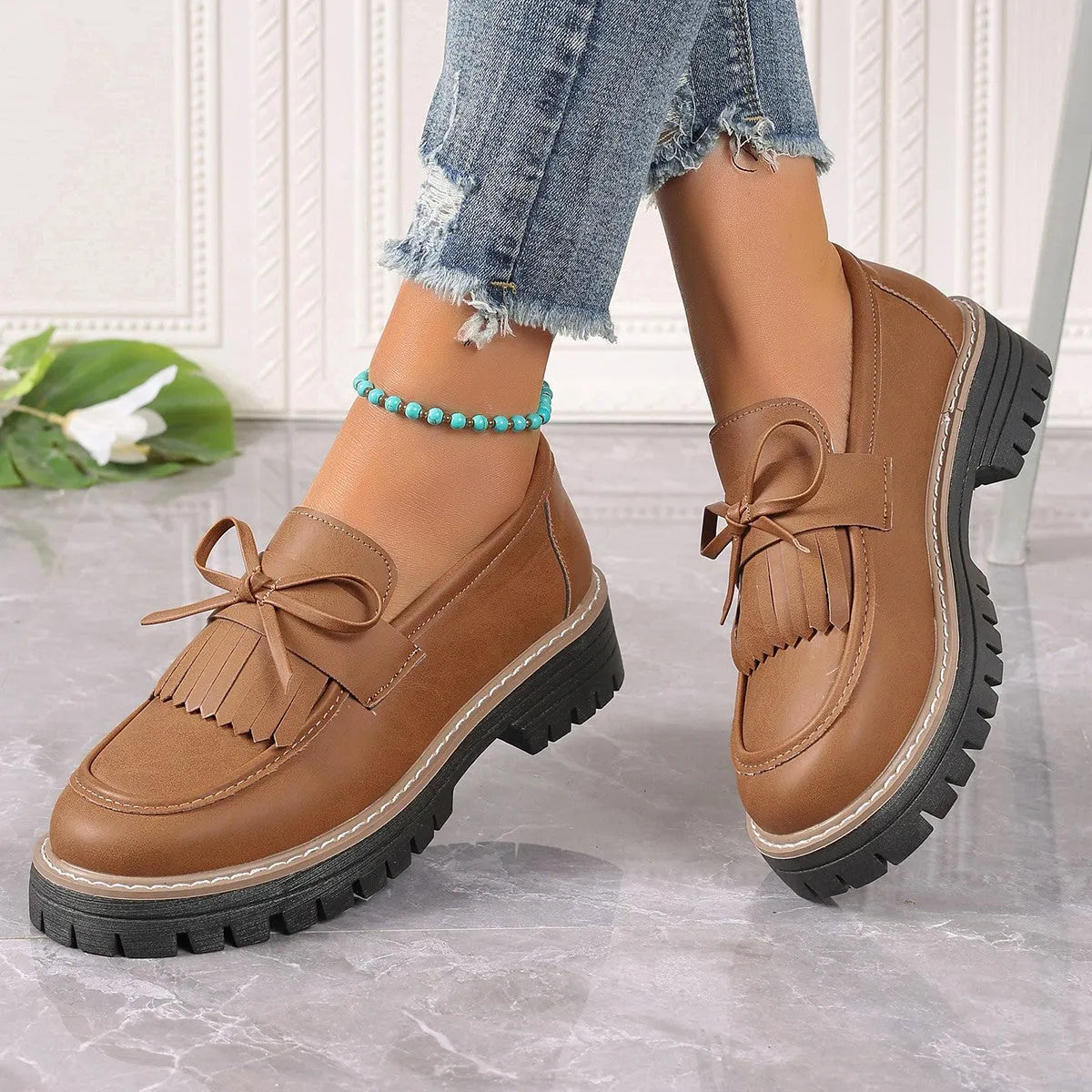 Black plus size women's loafers with tassel detail, bowknot, and a chunky low heel.