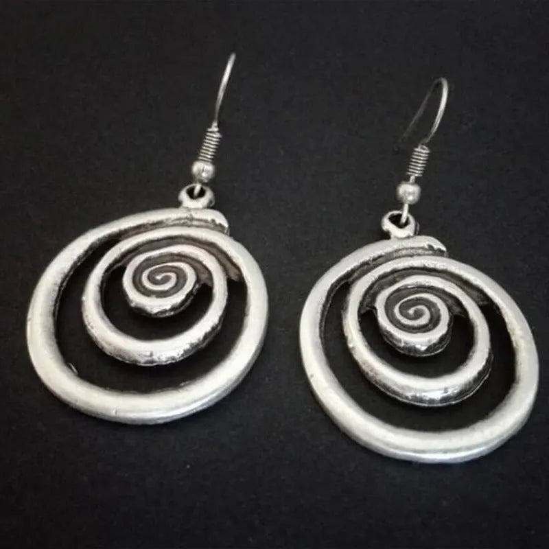 A pair of retro-style geometric spiral earrings with a distressed silver finish.