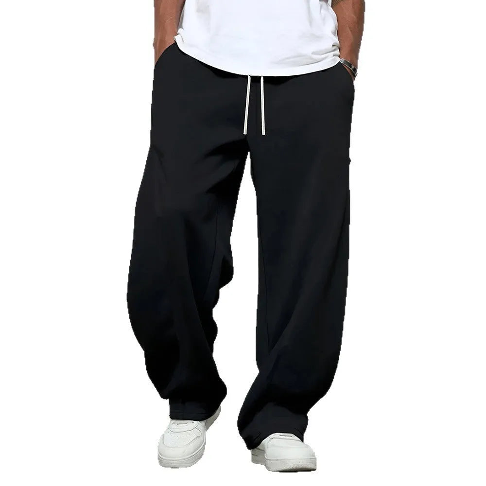 Man wearing grey micro-elastic casual trousers with a drawstring waist and straight leg.