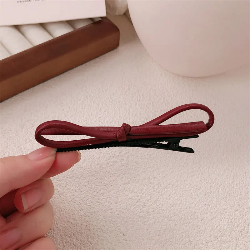 Wine red genuine leather bow hair clip barrette on a white background.