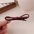 Wine red genuine leather bow hair clip barrette on a white background.