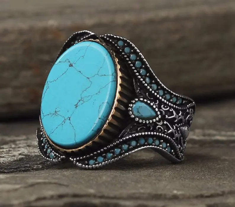 Men's antique silver ring with turquoise accent on finger showing simple round design