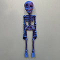Tall 3D printed white skull ornament with intricate detail placed on a refrigerator door.