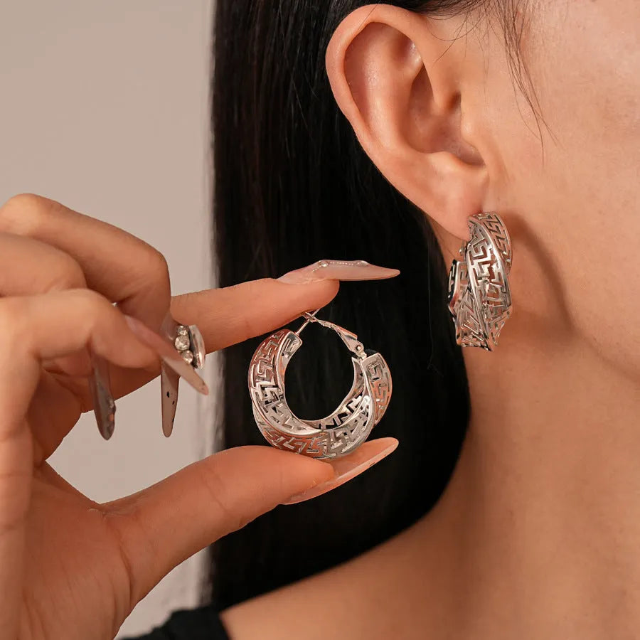 A pair of twisted round geometric hollow stud earrings in a silver electroplated finish.