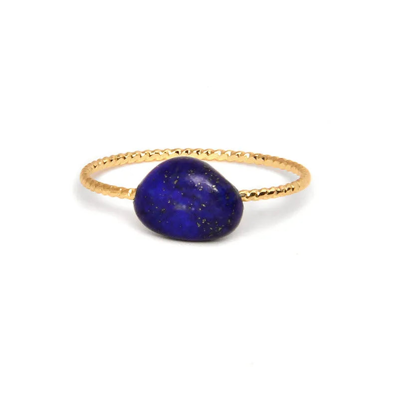A geometric silver-toned ring setting holding a polished oval agate stone in a blue-green colour.