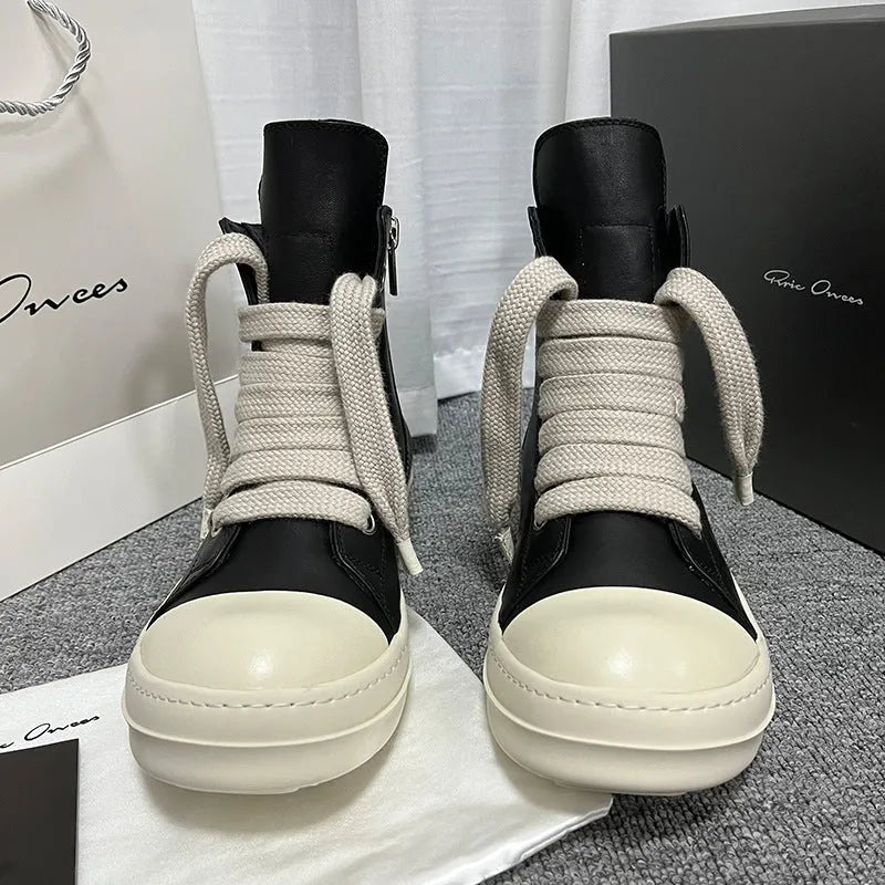 Black high-top leather sneakers with side zipper and round toe on a rubber sole.