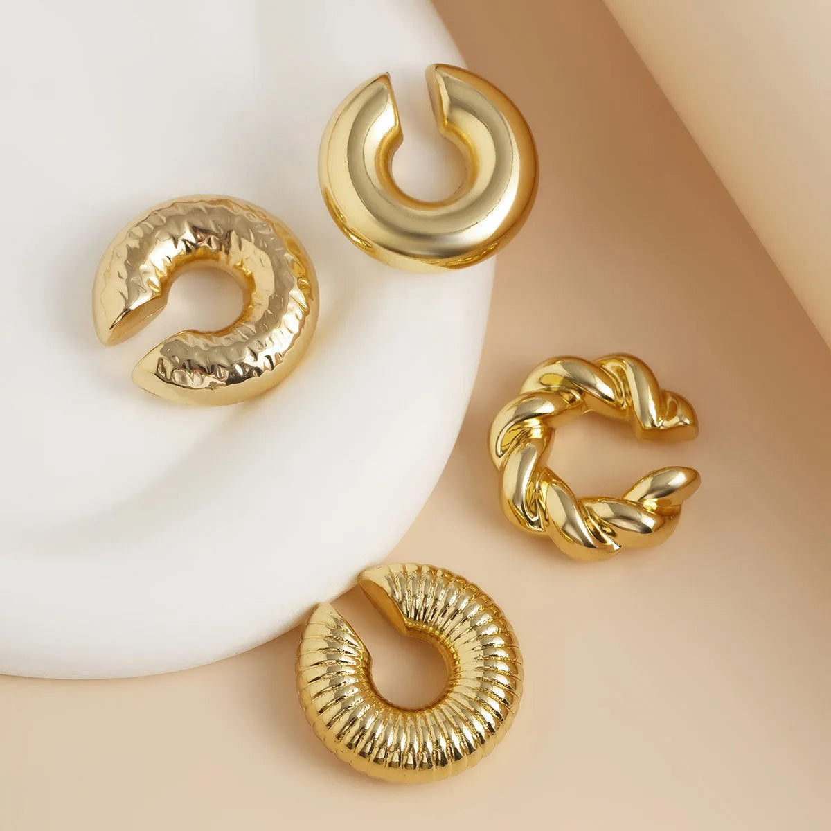 Set of four geometric clip-on earrings for women in gold and silver colours with exaggerated non-pierced design