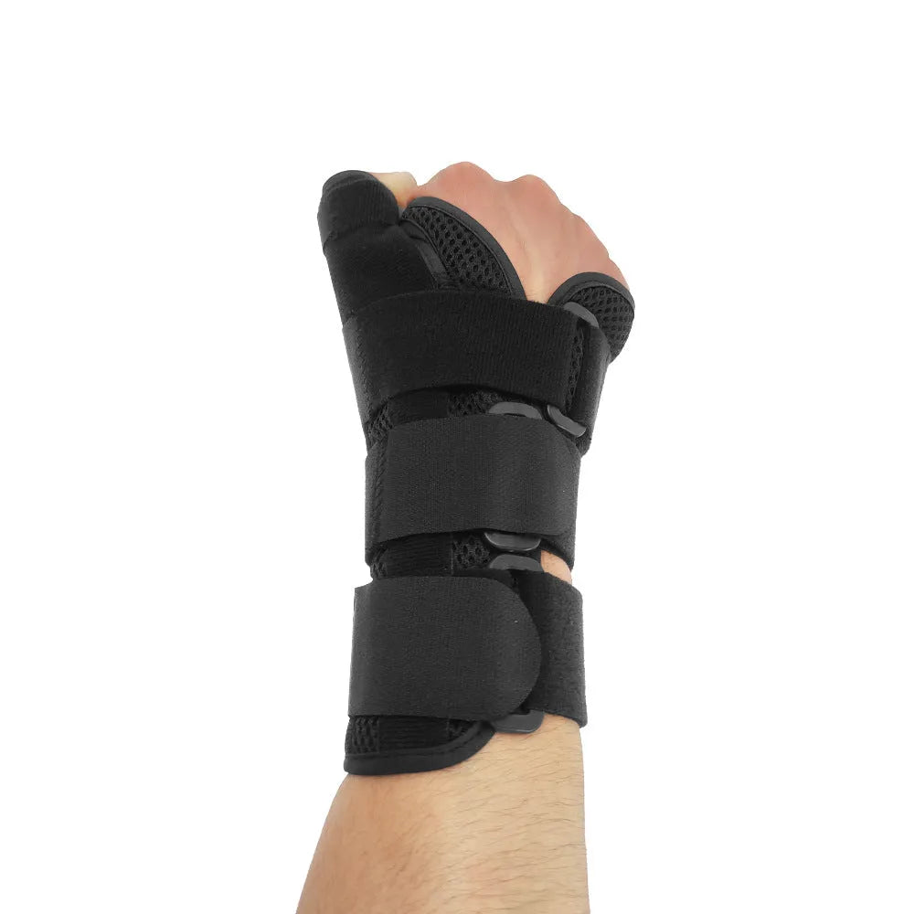 Black carbon fibre sports wrist guard with grey edging and an adjustable thumb strap laid flat.