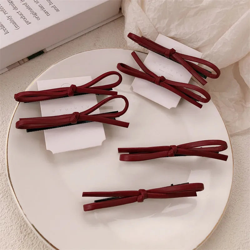 Wine red genuine leather bow hair clip barrette on a white background.