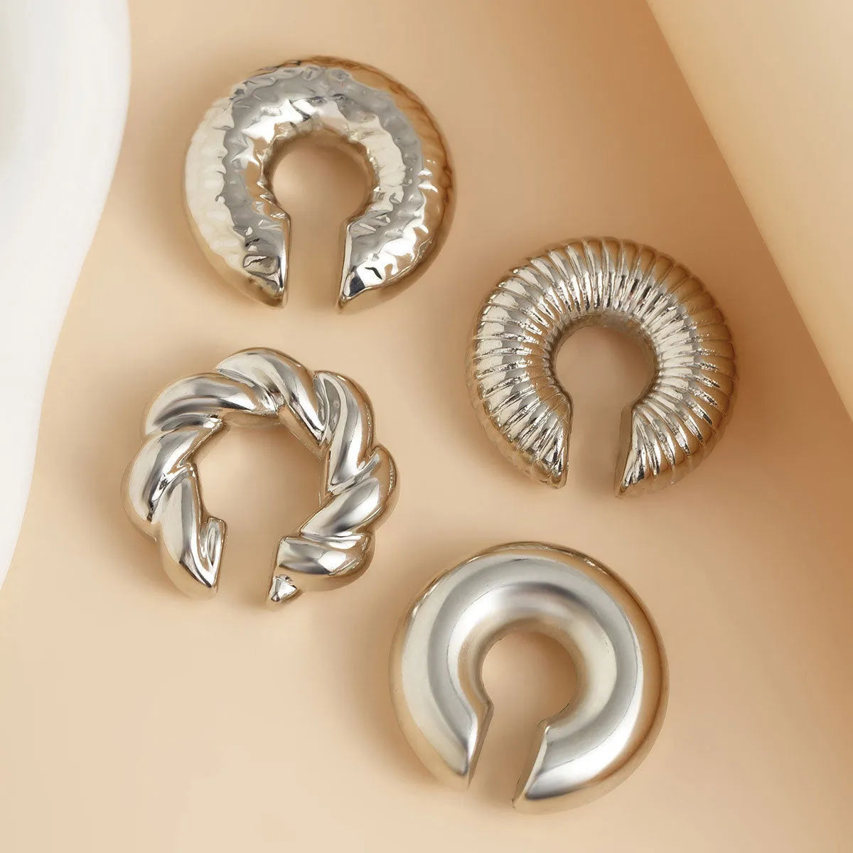 Set of four geometric clip-on earrings for women in gold and silver colours with exaggerated non-pierced design