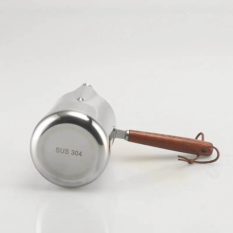Stainless steel latte art milk frothing jug with measurement scale and wooden handle