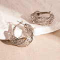 A pair of twisted round geometric hollow stud earrings in a silver electroplated finish.
