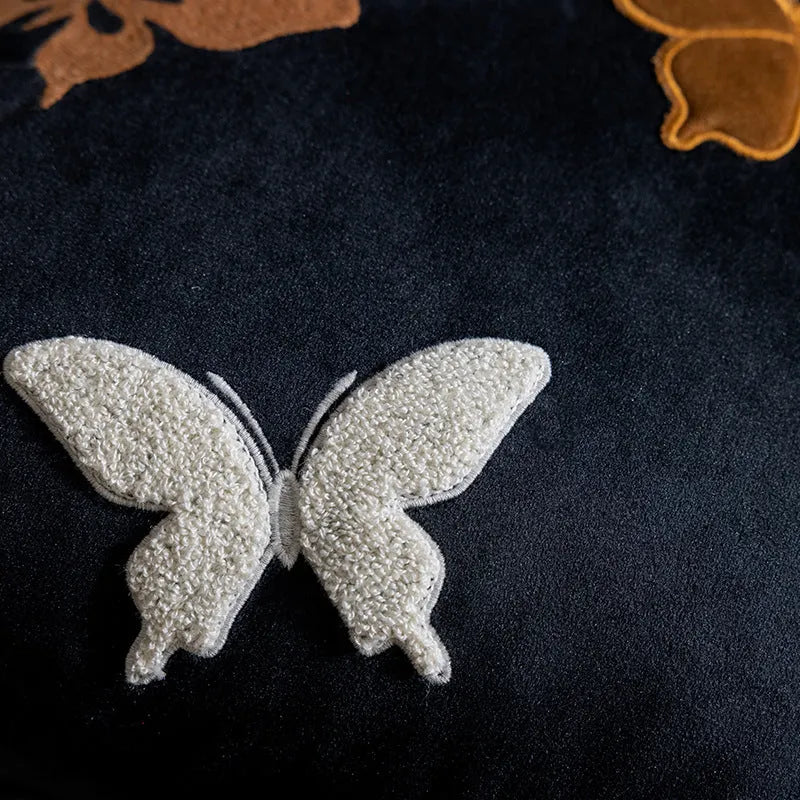Square beige, black, and purple cushion with Chinese style embroidered butterfly pattern.