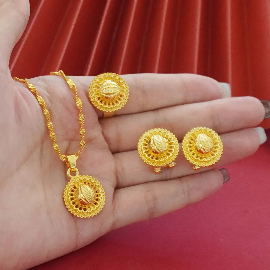 Gold-plated jewellery three-piece set with flower design pendant, matching earrings, and ring on display