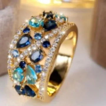 Women's round hollow ring with a gemstone, shown in gold and platinum with blue and white stone options.