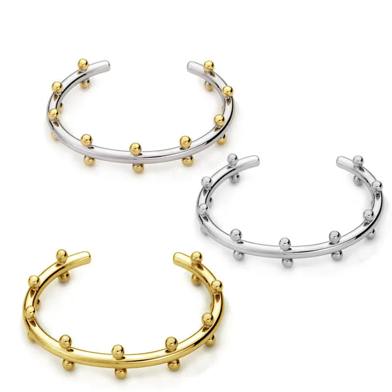 C-shaped stainless steel bracelet charm with textured surface and rivet bean beads in metallic finishes