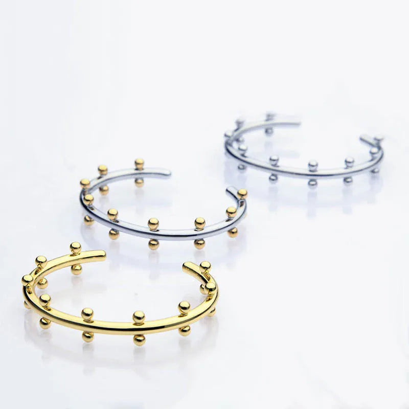 C-shaped stainless steel bracelet charm with textured surface and rivet bean beads in metallic finishes