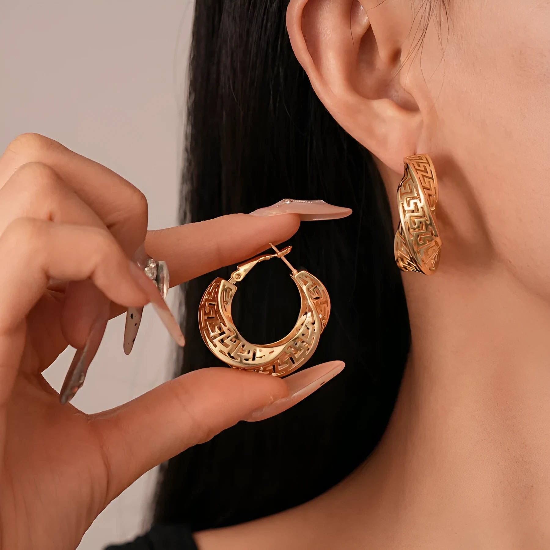 A pair of twisted round geometric hollow stud earrings in a silver electroplated finish.